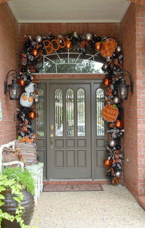 A Halloween front door decorated with black and orange pumpkins, ornaments, letters, bows and other stuff looks rather Halloween like
