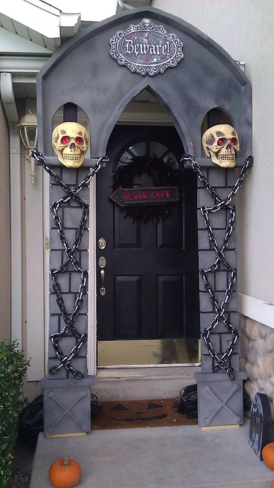 a Halloween styled porch with skulls, chains and a black feather wreath with a sign is a cool idea to go for