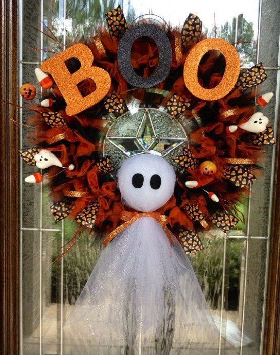 a bold Halloween wreath in rust and black, with a ghost, glitter letters and mini ghosts and corn candies is a lovely idea for the fall