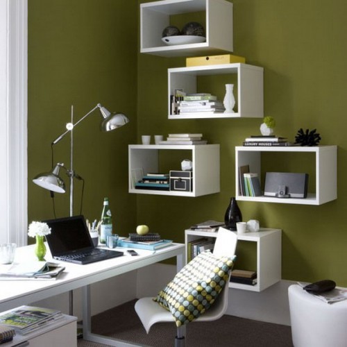 a grass green home office with white furniture, a white desk and box wall-mounted shelves, a white chair and a white pouf is a catchy and bold space