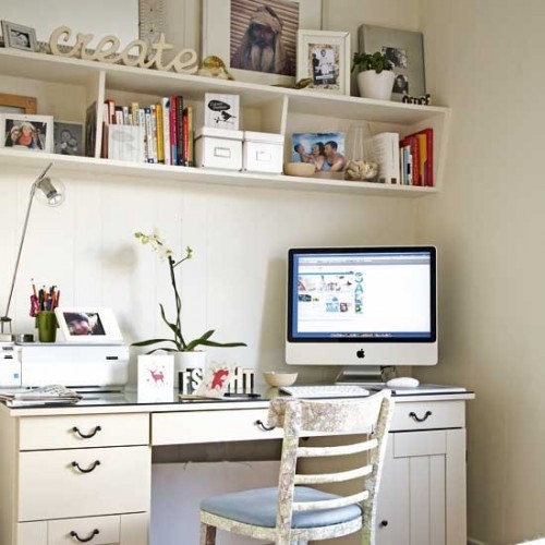 an ivory home office with open shelves, an ivory desk and a chair, with some plants, books and other stuff