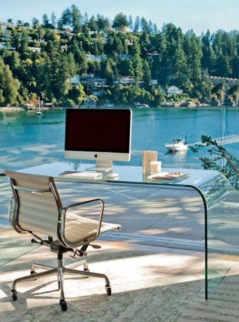 a jaw-dropping home office with a glazed wall that allows to enjoy a gorgeous lake view, an acrylic desk, a comfy chair - you won't need more