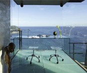 a jaw-dropping glass home office with a glass desk, acrylic chairs and amazing sea views – nothing distracts here from them