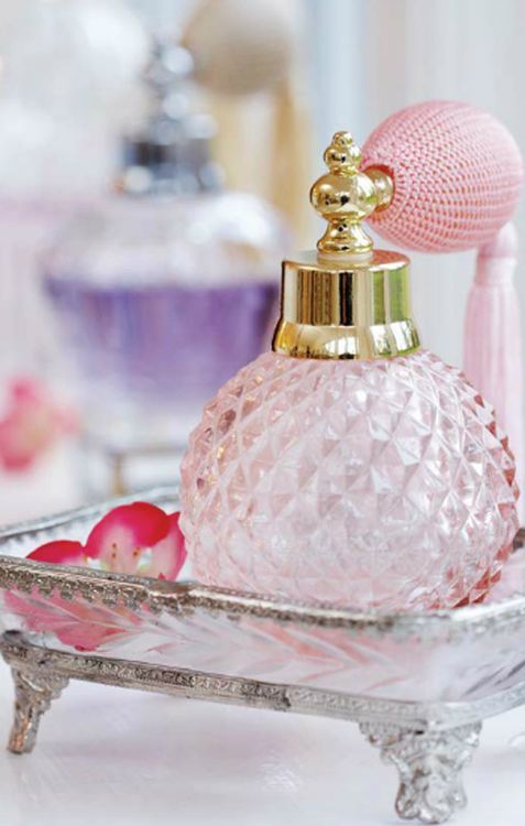 a vintage pink perfume bottle on a stand is a chic decoration for a closet or a makeup vanity, even if you don't ever use it