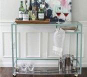 a lovely and easy home bar cart with a Vittsjo table hacked with casters and clear glass, with lots of wine and glasses