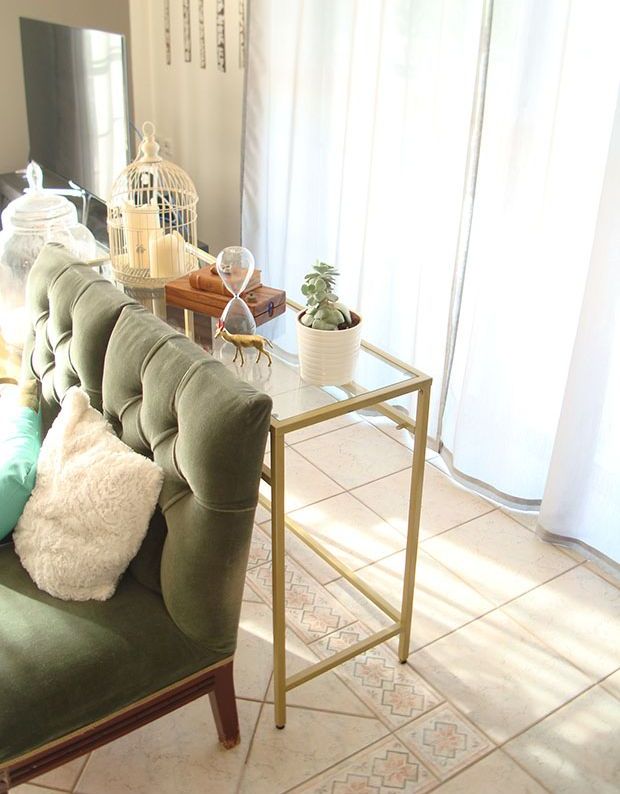 A gold Vittsjo table used as a console table, with a cage, potted plants and some other decor is a stylsih and cool idea