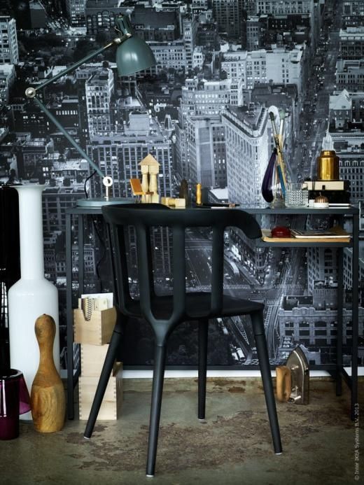 a moody working space with a black Vittsjo table as a desk, a black chair, some decor, glasses and a table lamp