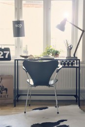a Scandi working space by the window, with a black desk that is a Vitssjo table, a modern black chair and a table lamp, some greenery to refresh the space