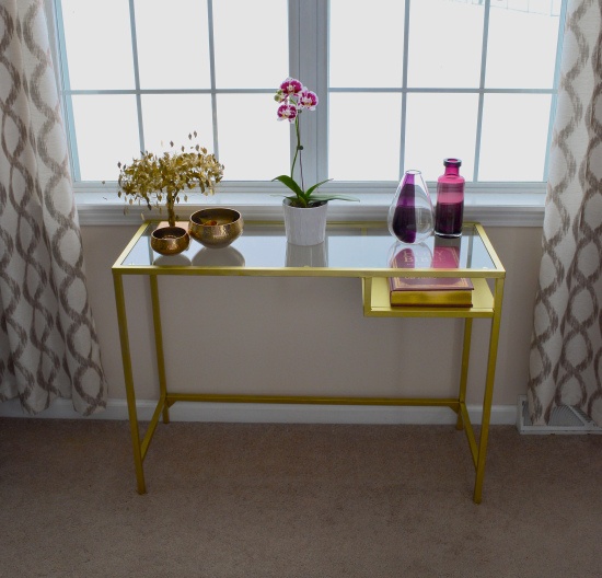 a glam IKEA Vittsjo table hacked with gold pant and used as a lovely console table, with blooms, pretty vases and a faux mini tree