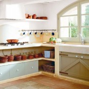 built-in kitchen furniture with open storage spaces for tableware and some drawers for storage is a great solution for a rustic space