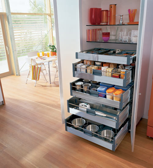 A built in pantry with glass shelves and several drawers for storage and even pets' bowls down there