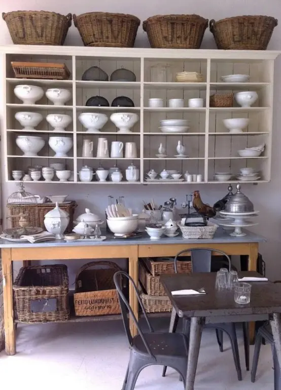 a large open wall-mounted shelf with baskets on top and an additional kitchen island with a storage space for holding a lot of things