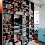 an oversized open shelving unit is used to separate the spaces and hold everything the owners may need, it’s a great idea
