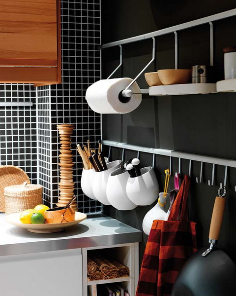 A wall mounted metal holder with two tiers and shelves, with holders for various stuff and utensil holders