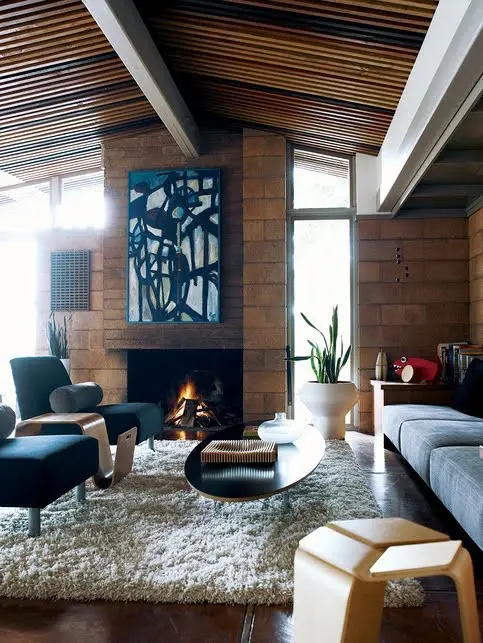 A gorgeous mid century modern meets contemporary living room with large brick walls