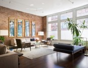 a contemporary living room with a red brick statement wall and a matching rich stained wooden floor