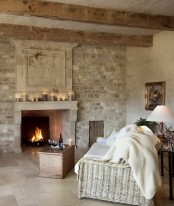 a French farmhouse living room with a statement white brick wall and a built-in fireplace