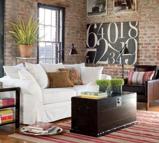 a boho chic living room with muted red brick walls, boho textiles and potted greenery