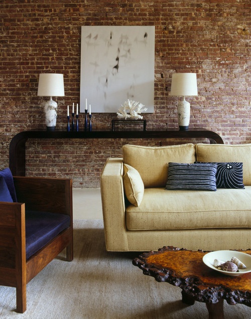 a refined living room is made less formal with a red brick statement wall, which also brings texture