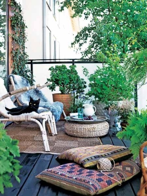 a Scandinavian deck with wooden furniture, jute ottomans and rugs and potted greenery