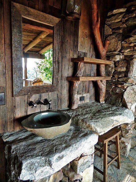 a wabi-sabi bathroom with wood, stone and concrete plus a large mirror and a stone vanity