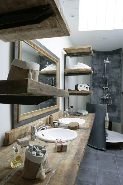 a contemporary meets industrial bathroom with much light-stained wood and dark tiles and concrete