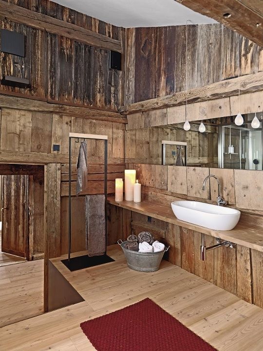 a rustic meets vintage bathroom with candles and lamps plus a tub with towels