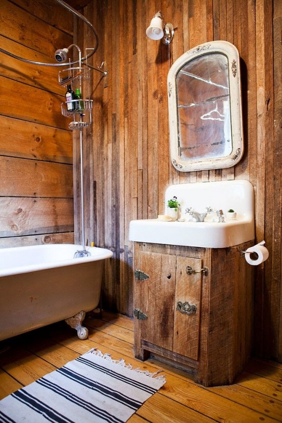 a rustic bathroom all clad with wood and with vintage items