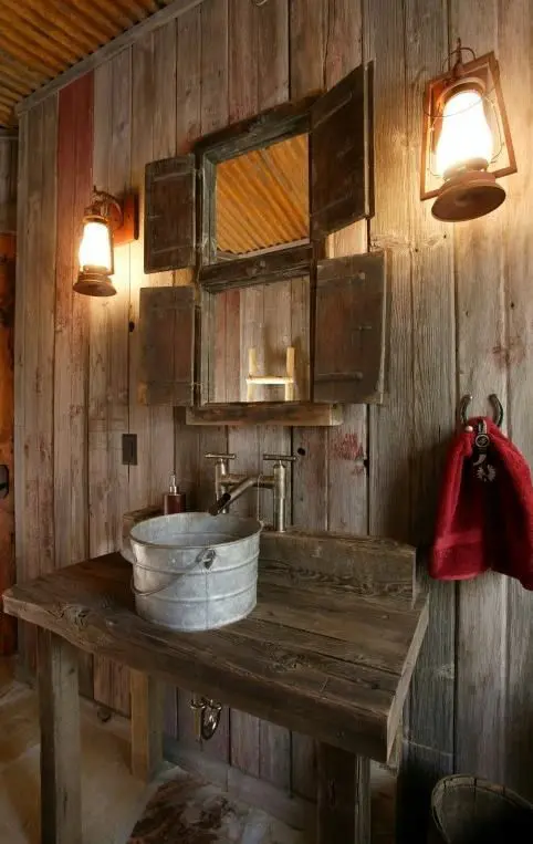 a rustic meets vintage bathroom with much stained wood and a sink made of a metal bucket