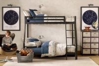 a stylish shared teen boy bedroom with a black bunk bed, a map covered cabinet, sky maps on the walls and comfy chairs