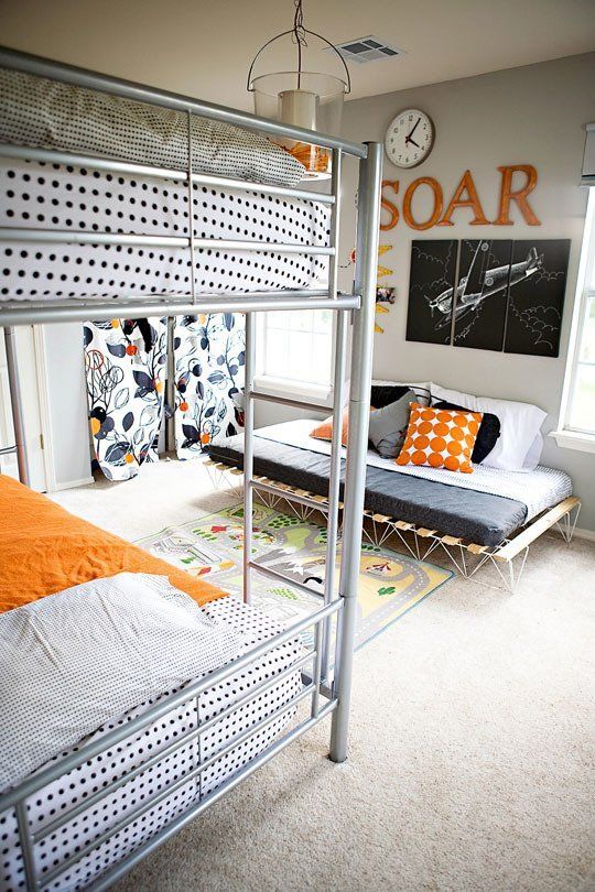 a simple shared boy bedroom with a bunk bed, a pallet sofa for chilling and a privacy nook with curtains