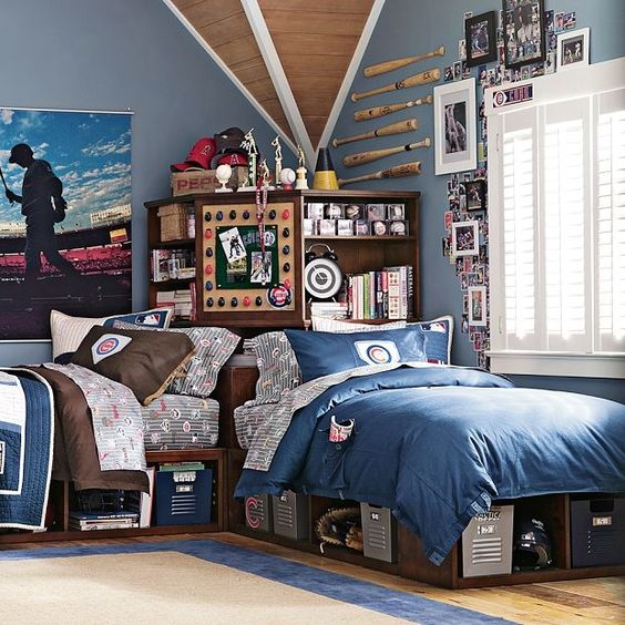 A blue shared teen boy bedroom rich stained beds, a storage unit, a sport inspired gallery wall and baseball items on the wall