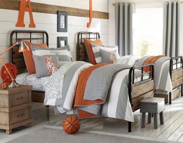 a rustic vintage shared teen boy bedroom with white walls, metal beds, wooden furniture and neutral and orange textiles