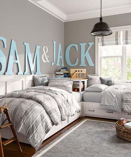 a neutral rustic shared teen boy bedroom with paneling, white furniture, baskets, a ladder and an industrial lamp