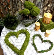 moss balls, moss hearts, a moss cube and candles in wooden candleholders for a springy feel