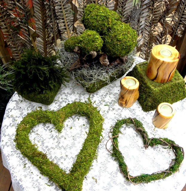 Moss balls, moss hearts, a moss cube and candles in wooden candleholders for a springy feel
