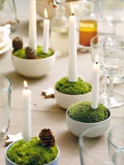 cups with moss and candles plus pinecones for a cool sprign centerpiece or decor with a woodland feel