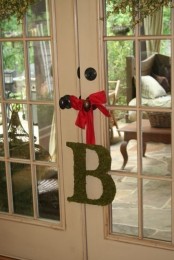 a moss monogram with a red ribbon is a cool indoor or outdoor decoration for spring