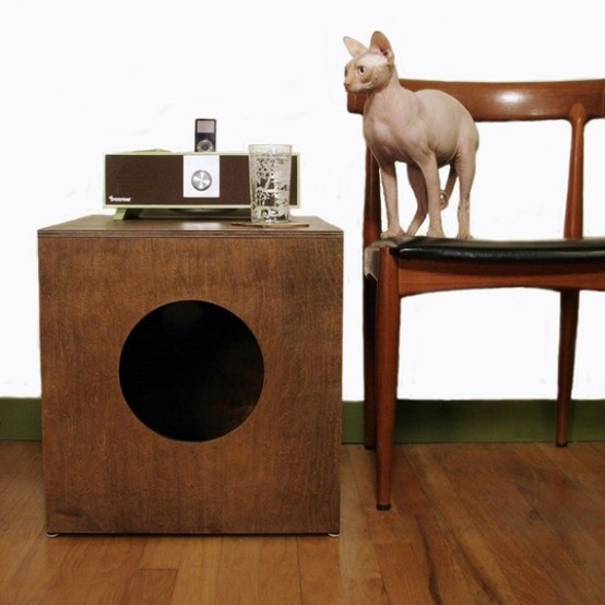 a dark stained box with a round entrance and a cat litter box inside is a stylish solution for a mid-century modern space