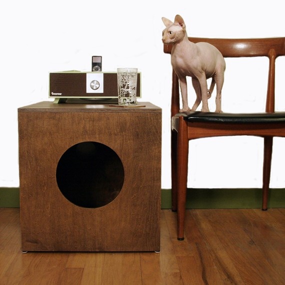 A dark stained box with a round entrance and a cat litter box inside is a stylish solution for a mid century modern space