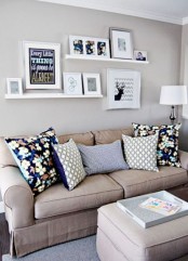 a modern neutral living room spruced up with bold pillows, with white ledges and various artworks is a very cool idea