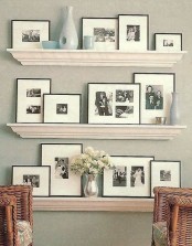 elegant white ledges with black and white family pics and blue vases is a chic and stylish idea for a farmhouse space