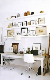 a work space with ledges over the desk, with branches, artworks, vases, antlers and skulls for personalizing the space and making it bolder and cooler