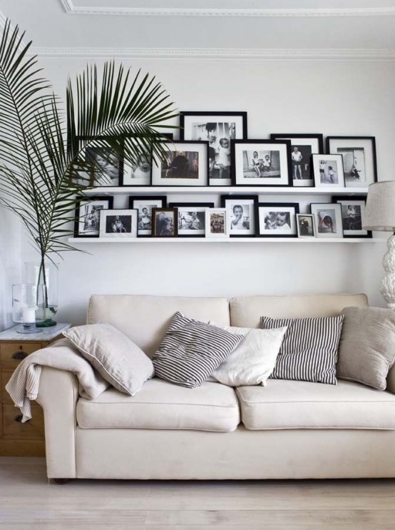 a neutral living room personalized with long white ledges that show off black and white photos of the whole family
