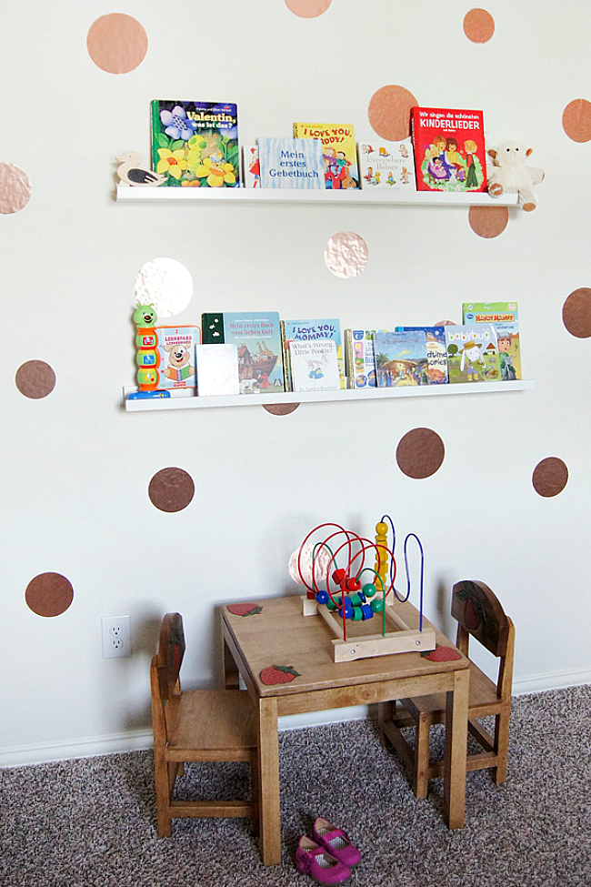 A playroom with ledges over the table with kids' books   this is a simple and cool idea to store books without using floor or table space