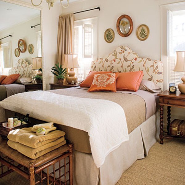 A bright fall inspired bedroom with a floral upolstered bed, touches of neutrals and muted shades plus orange accents
