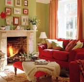 a bright red sofa, striped orange curtains and a fall-inspired gallery wall make this living room fall-like