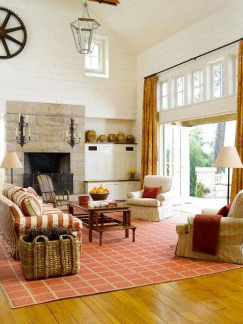 Rust colored curtaints, a rug and a striped sofa add fall aesthetics to the living room