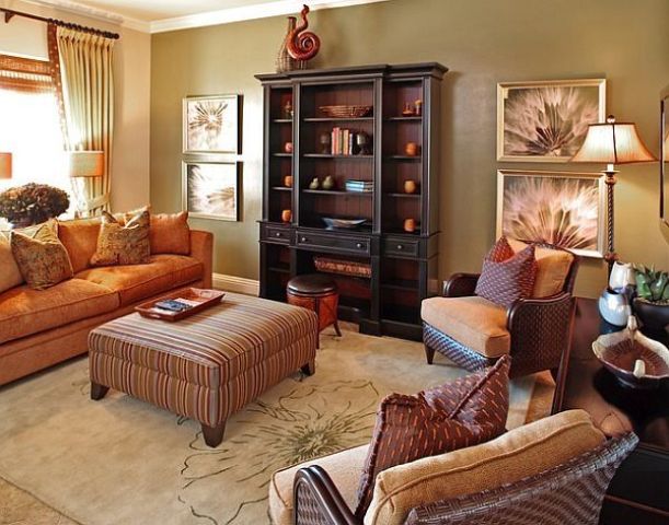 An orange sofa, printed pillows and an ottoman make up a bright fall colored space