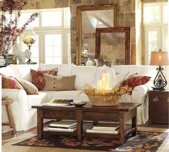 bright printed pillows, a bright floral arrangement and a basket with blooms and candles for a fall feel